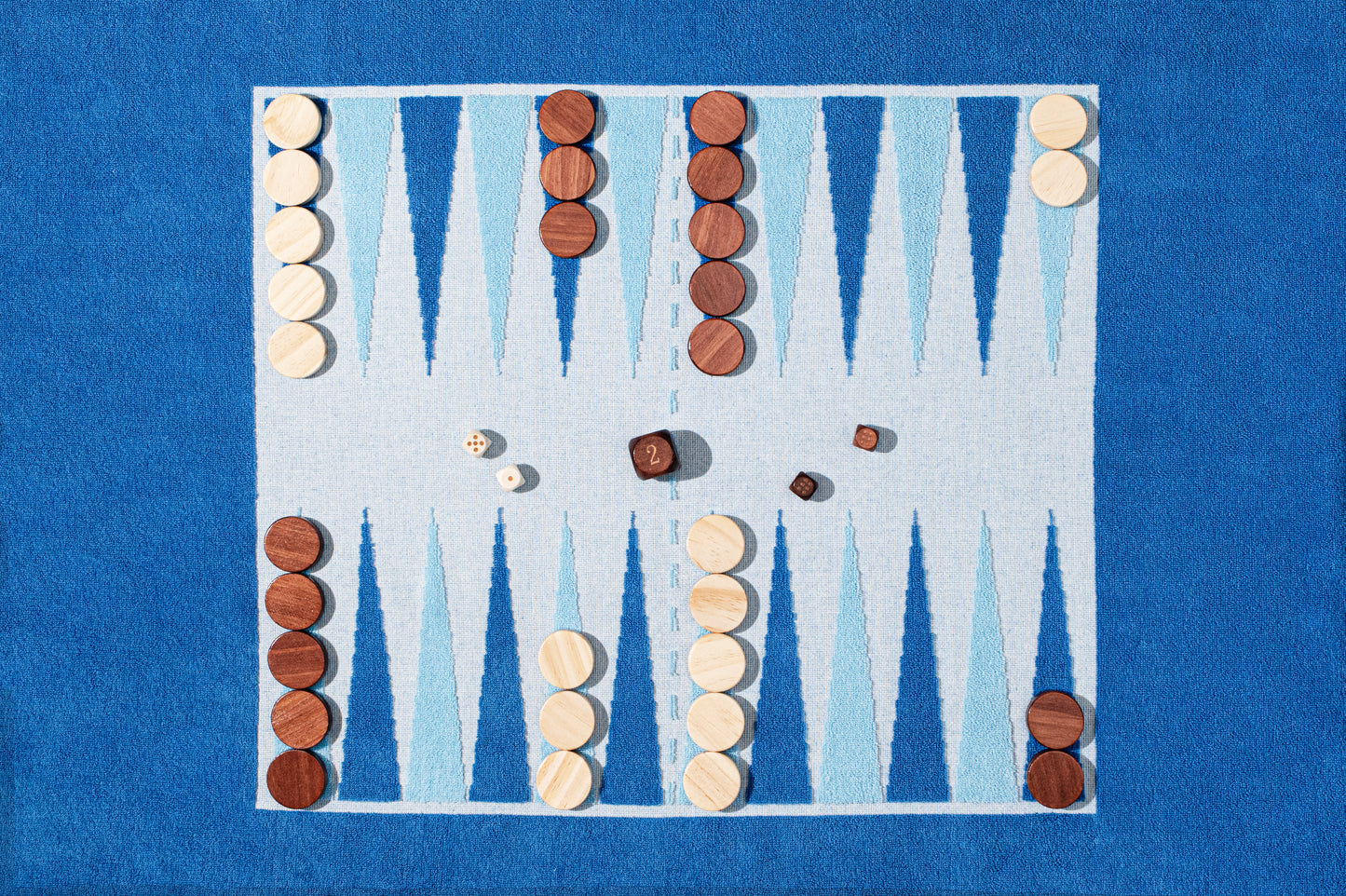 close up of terry backgammon board with wood pieces, set and ready for play