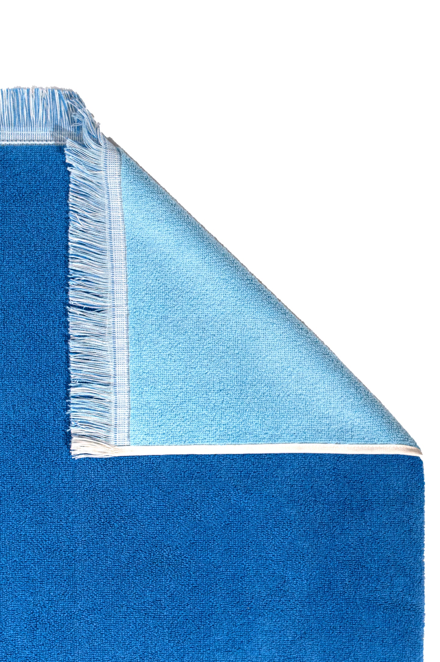 Product close up of corner of terry towel, showing detail of fringe border and reverse color of towel