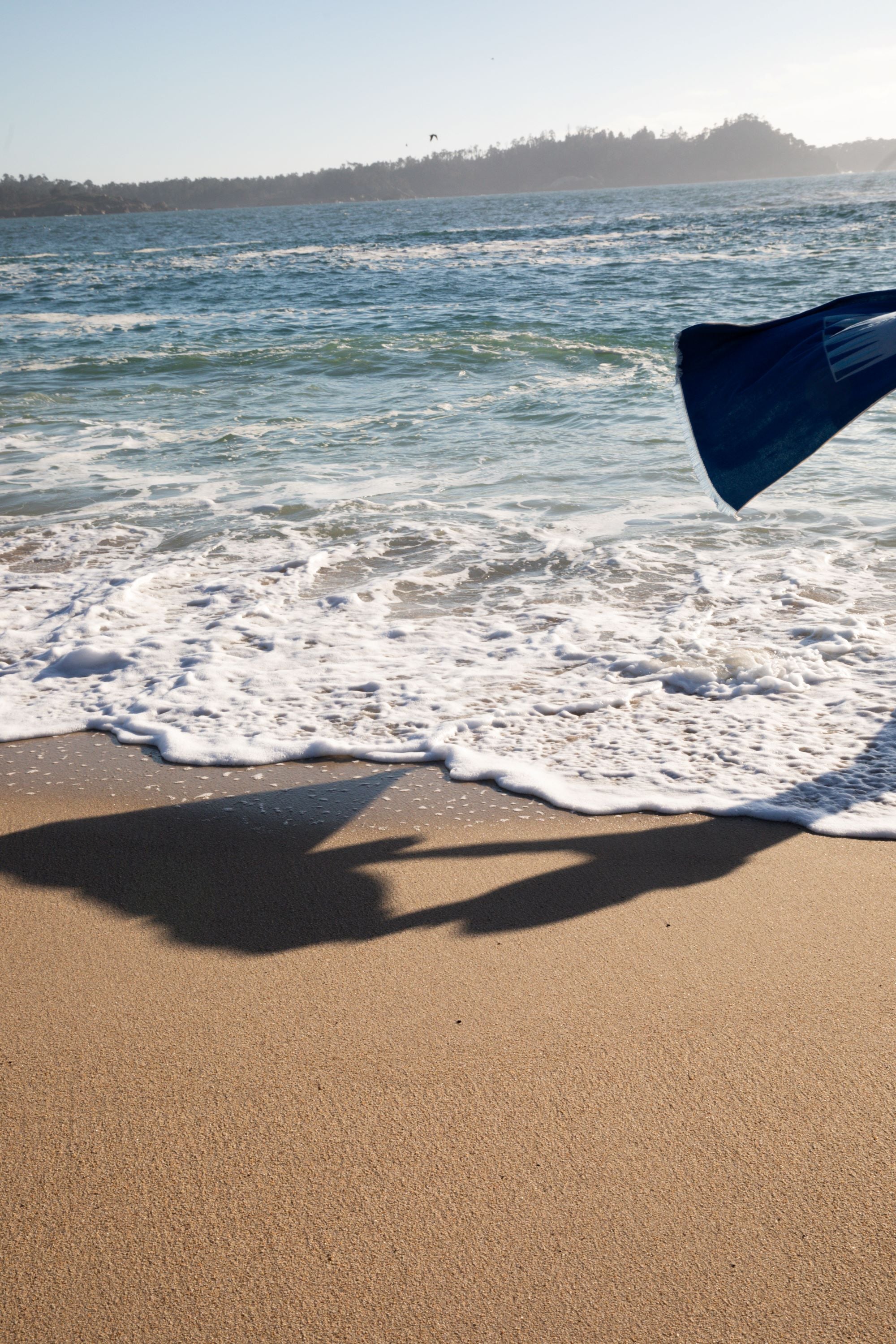 Photo of ocean with towel being suspended in the air by a gust of wind