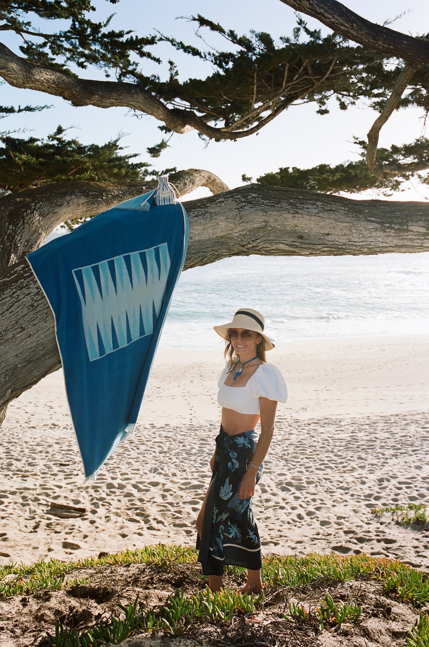 Photo of founder and CEO on a beach with her Beach Board product, hanging from a tree