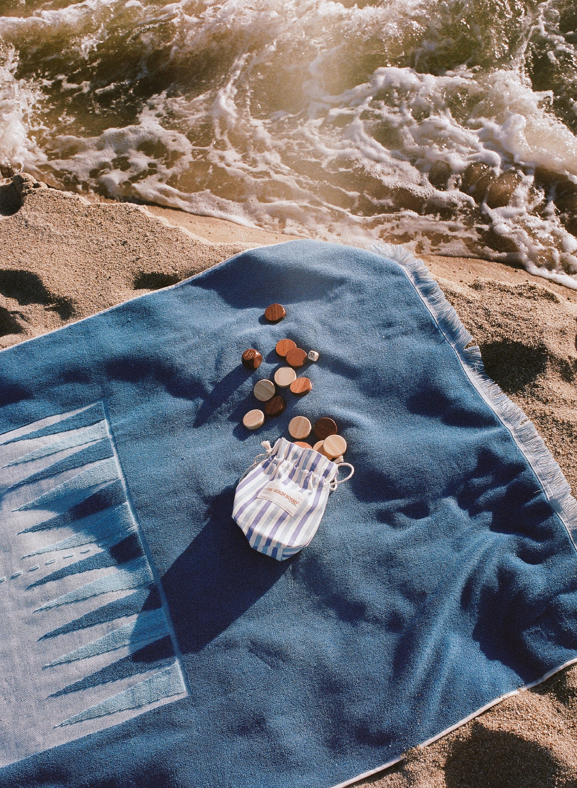 Artistic lookbook photo, shot in film, of the Beach Board next to an ocean swell