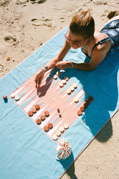 Photo of girl playing backgammon at the beach on her Beach Board