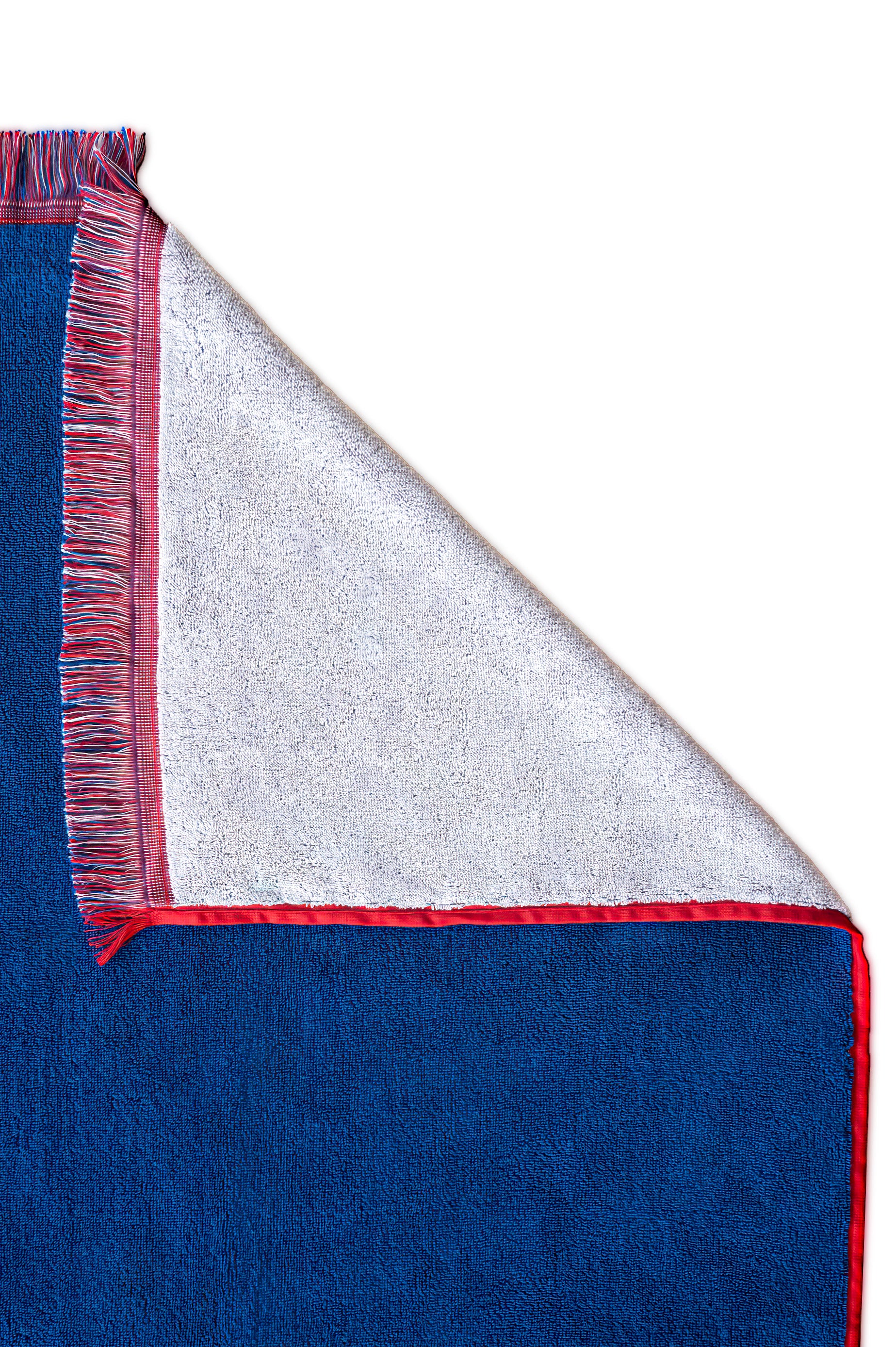 Folded corner showing details of terrycloth beach board, red white and blue coloring and fringe border